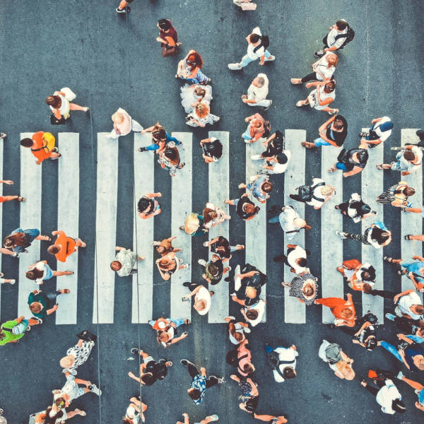 Aerial. People crowd on pedestrian crosswalk.