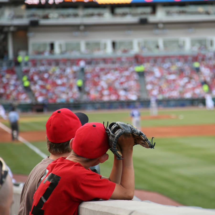 Two people at a baseball game, one with a glove in his hand.